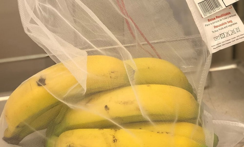 Białe woreczki na zakupy Rolser SHB027, siatkowy woreczek z bananami i metką producenta