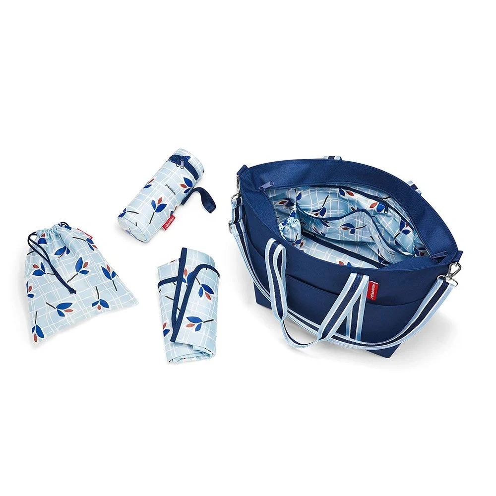 Granatowa torba do wózka Reisenthel Baby Organizer otwarta, obok mata do przewijania, termoetui i woreczek