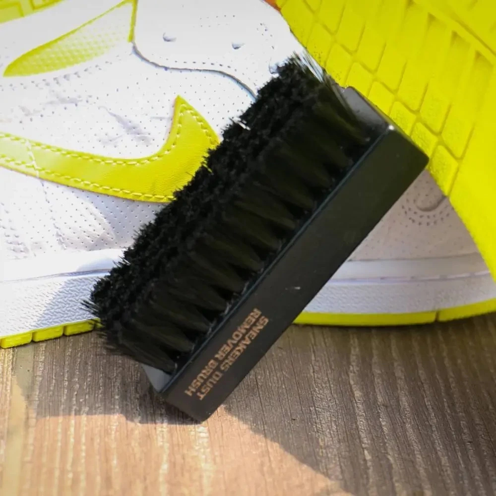 Szczotka do butów Tarrago czarna - szczotka oparta o sneakersa