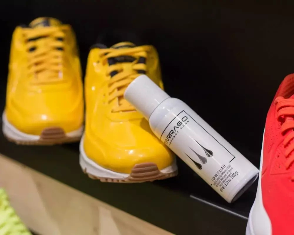Odświeżacz do obuwia sportowego Tarrago - opakowanie między żółtymi i czerwonymi sneakersami