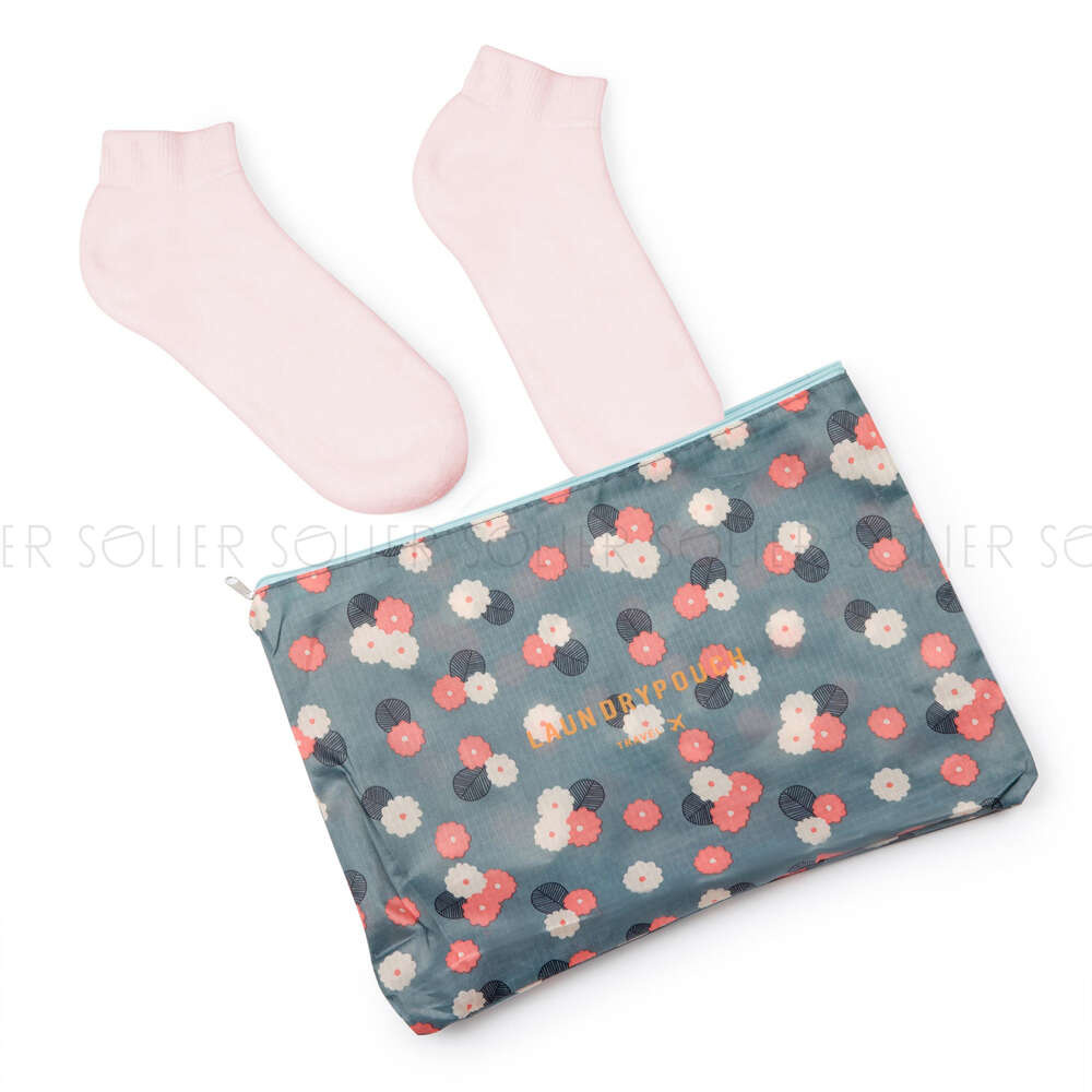 Niebieskie organizery do walizki Solier SA55 z poliestru, saszetka w kwiaty z napisem Laundry Pouch obok skarpetek