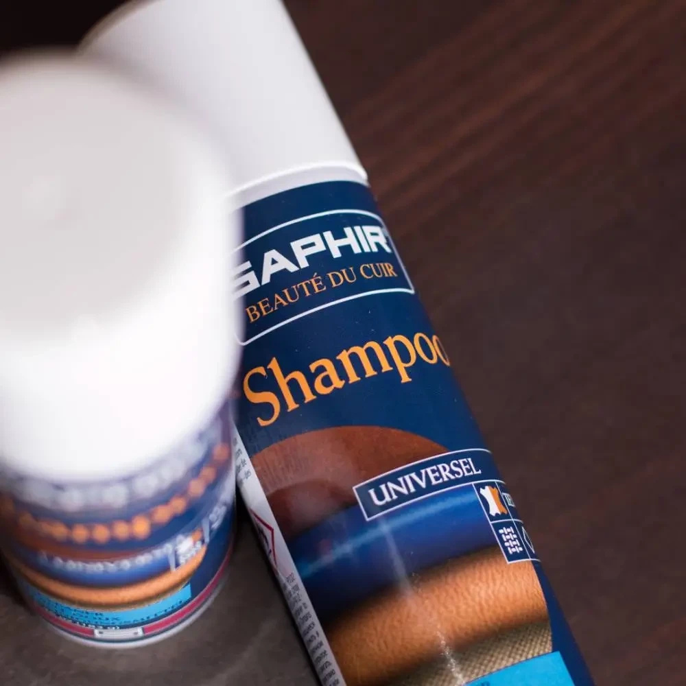 Pianka czyszcząca delikatny do skóry i tekstyliów Saphir - zbliżenie dwóch puszek Shampoo na drewnianym blacie