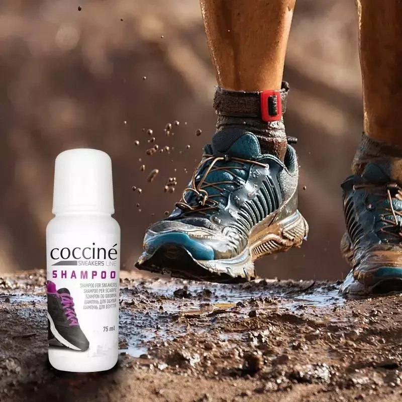 Szampon do sneakersów Coccine - butelka na tle butów biegowych w błocie